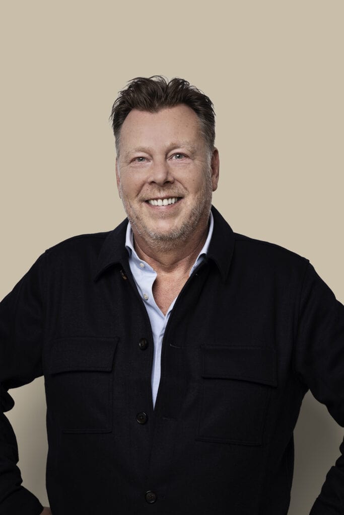 Mannelijke zakelijke professional poseert voor een neutrale achtergrond, geschikt voor bedrijfsportretten, coaching of persoonlijke branding, met een vriendelijke uitstraling en professionele uitstraling.