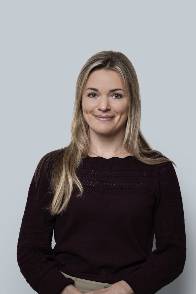 Gezicht van jonge vrouw met blonde haar in professionele fotostudio, zakelijk portret voor branding en LinkedIn, neutrale achtergrond, goed verlicht, moderne zakelijke uitstraling.