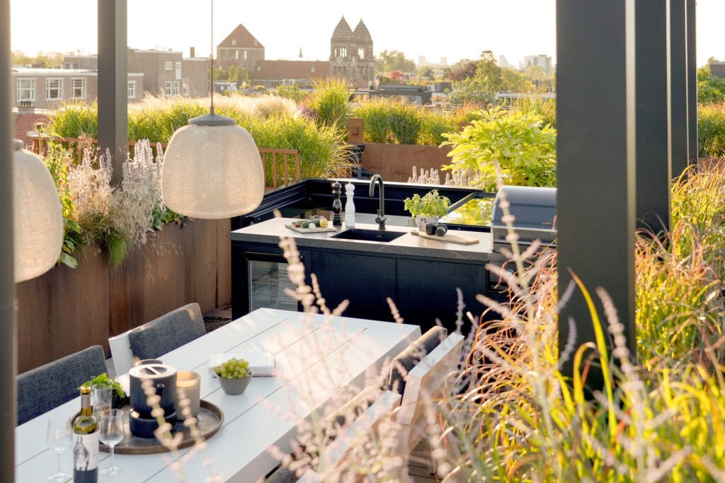 Ruim balkon met tuin en buitenkeuken, perfect voor genieten van de stadssfeer en buiten eten.